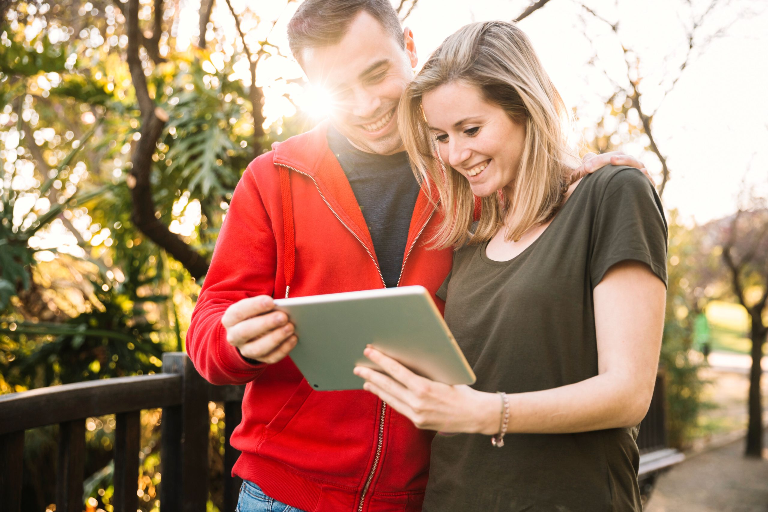  couple standing in the driveway or entryway, holding a clipboard or tablet